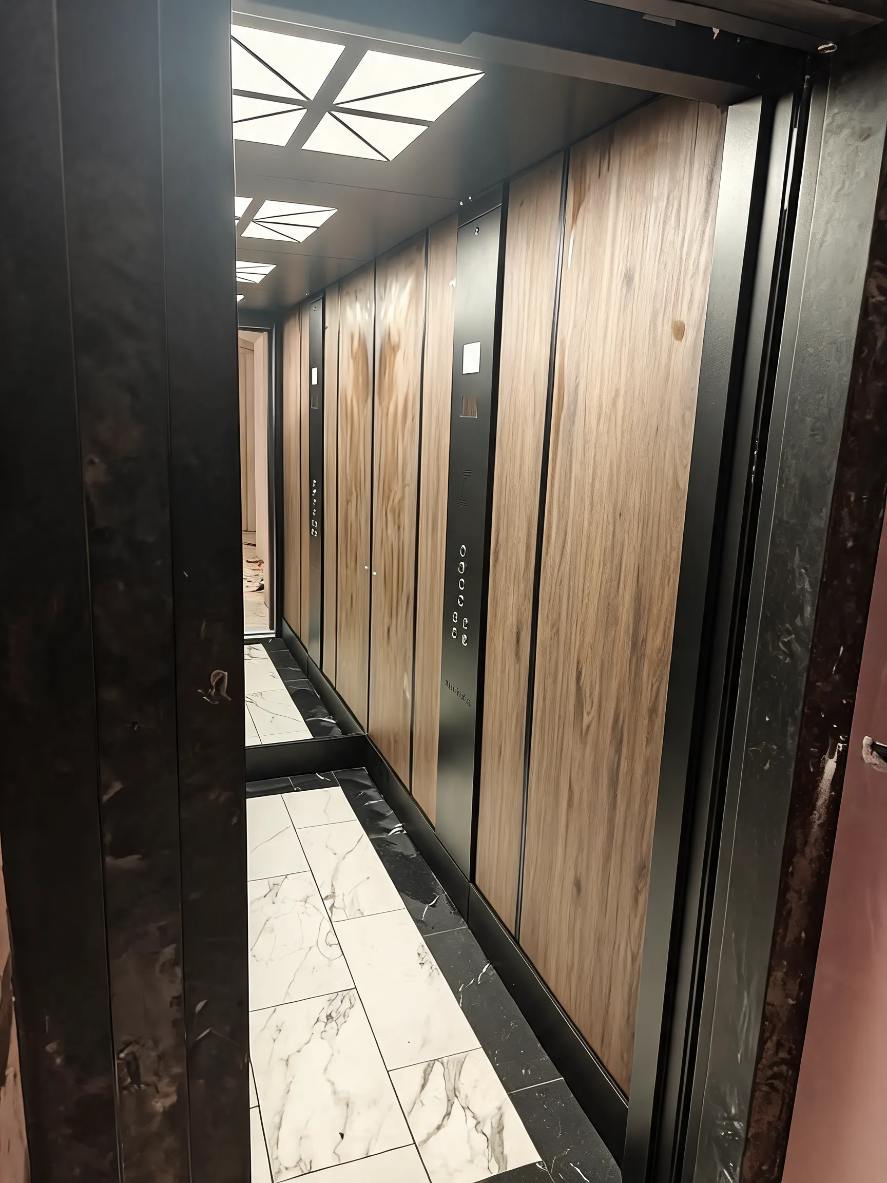 Wnętrze kabiny: panele drewnopodobne, czarny panel dyspozycji, sufit z trójkątnymi lampami
