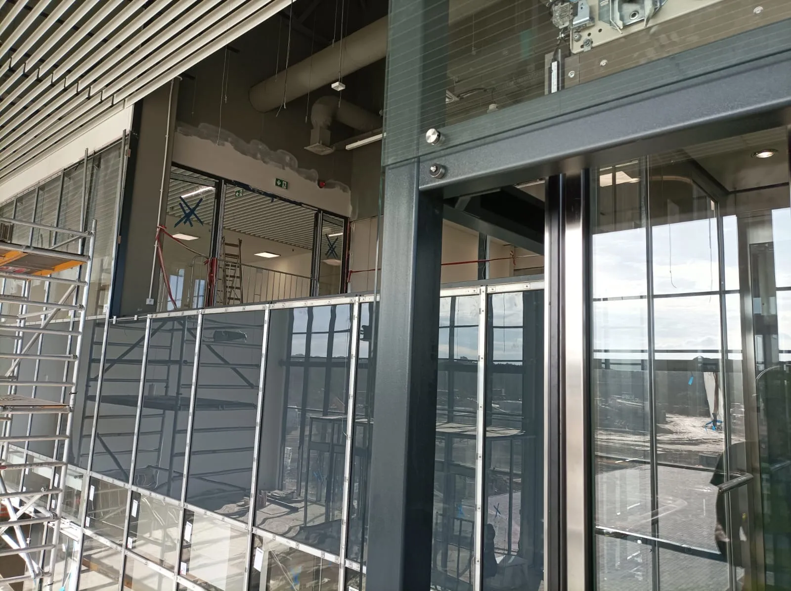 Drzwi przystankowe na antresoli w stalowej ramie, balustrada ze szkła wzdłuż krawędzi